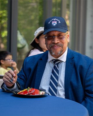 Smiling alumnus sitting at the Penn Engineering Alumni Weekend table.